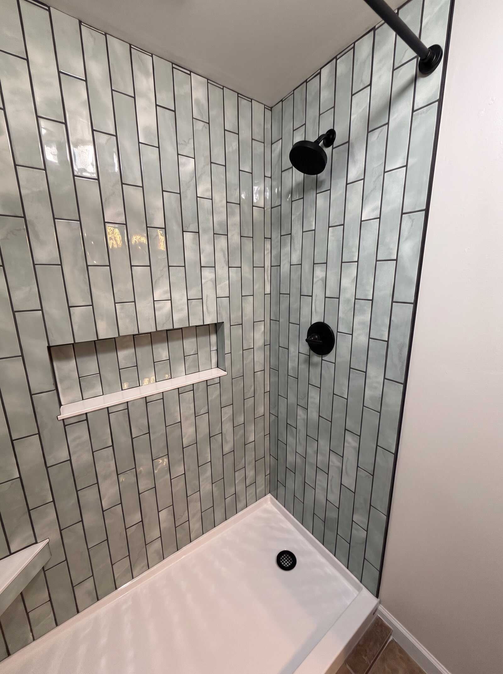 Vertical stacked tile shower with black fixtures