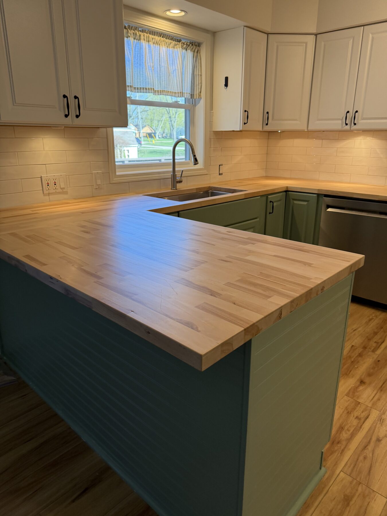 Kitchen remodel with butcher-block counters and sage green cabinetry